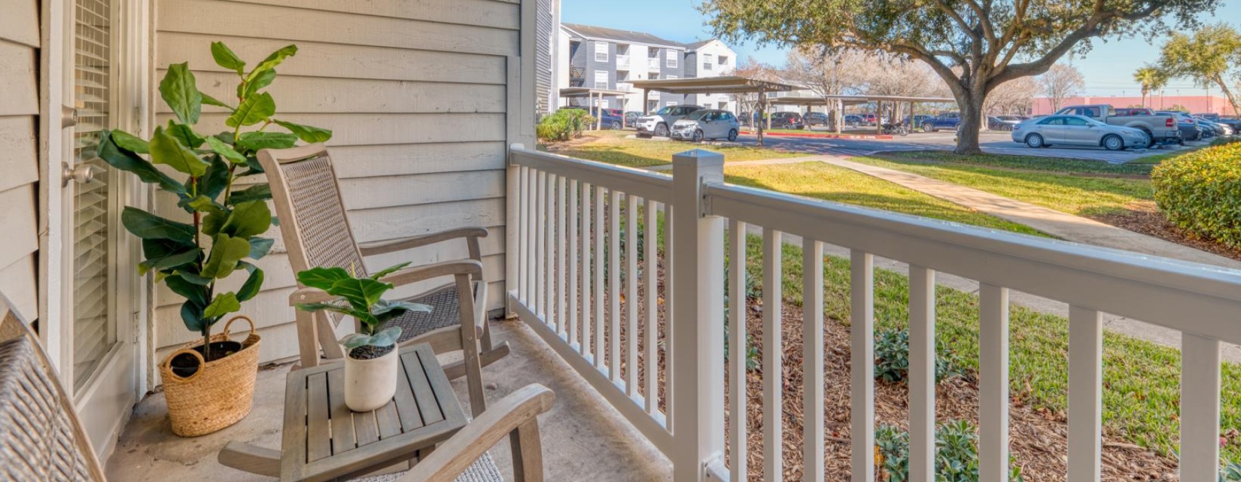 a patio with a table and chairs and plants on it